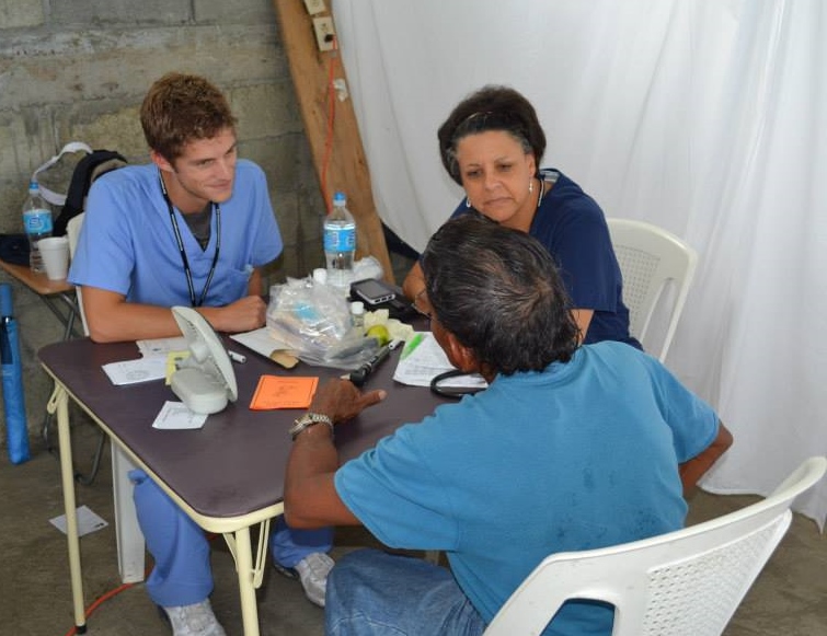 2 medical people talking to a patient