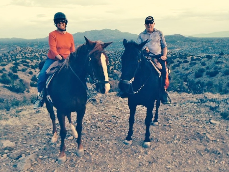 a man and woman both on horses