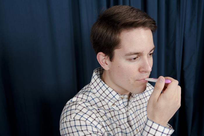 a man taking his temperature