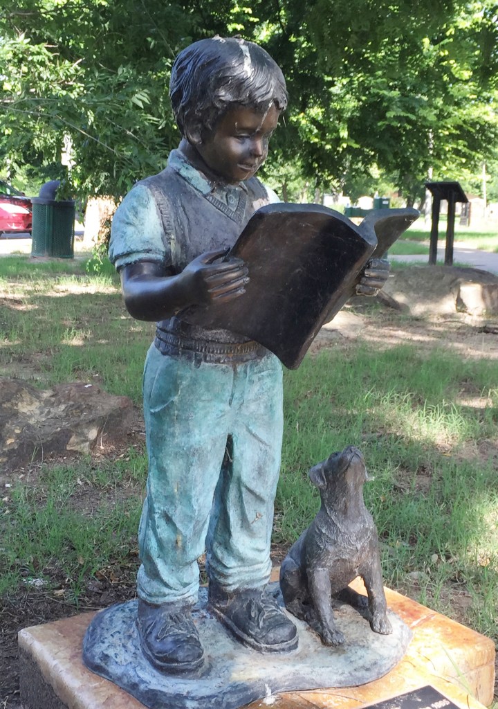 statue of boy reading a book
