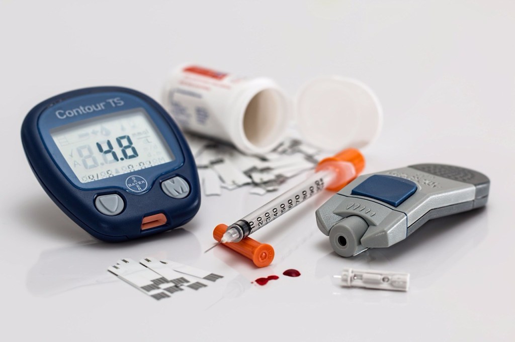 a glucometer and insulin syringe