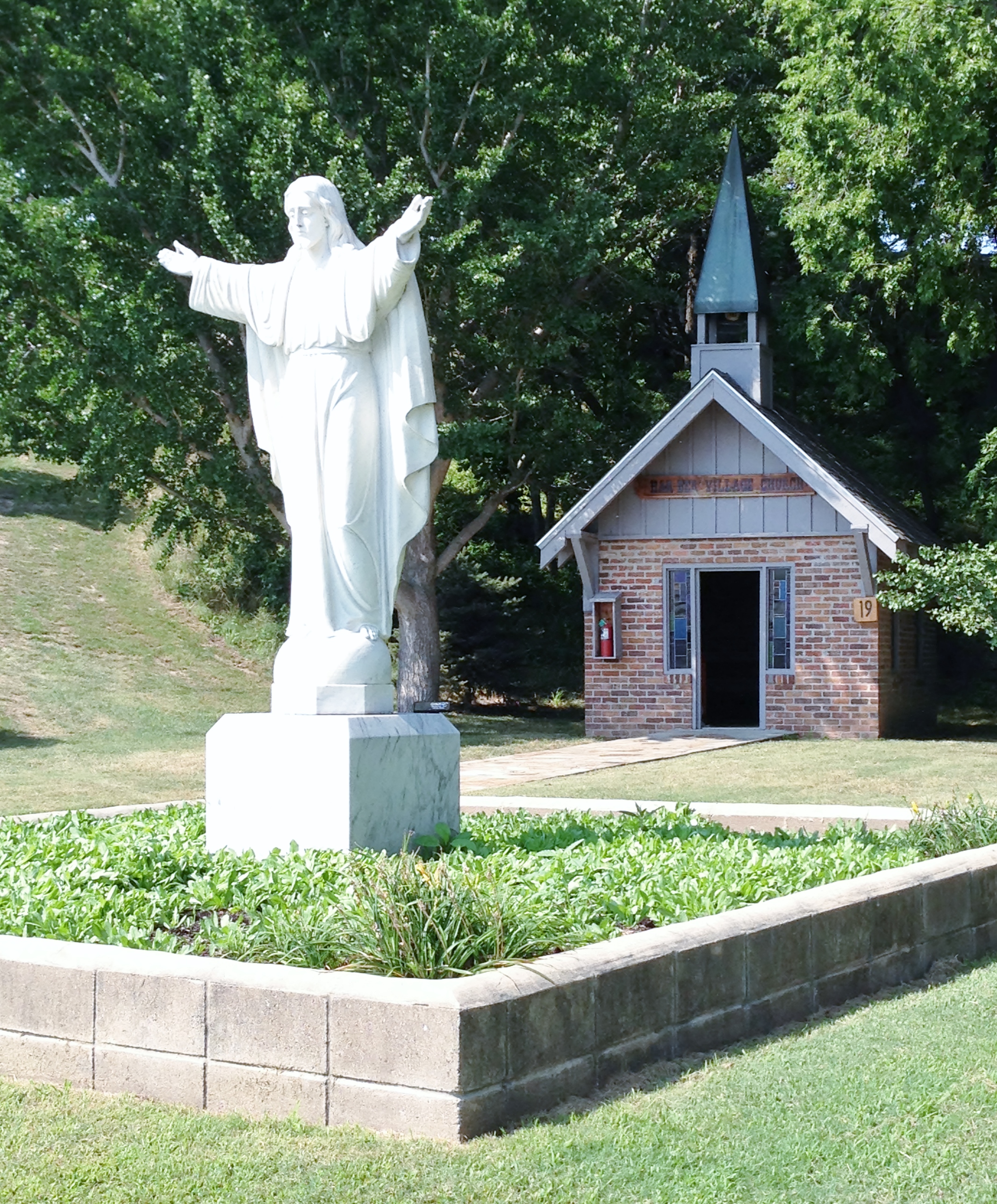a statue of Christ and a small church