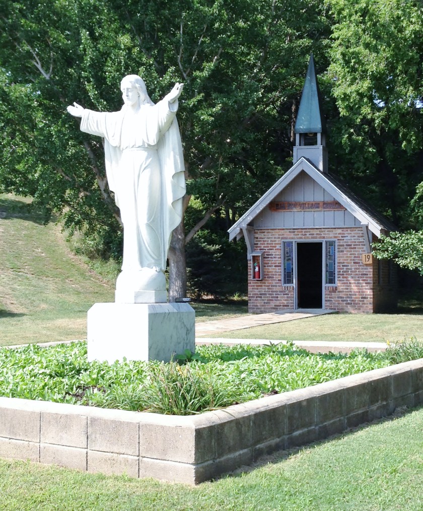 a statue of Christ and a small church