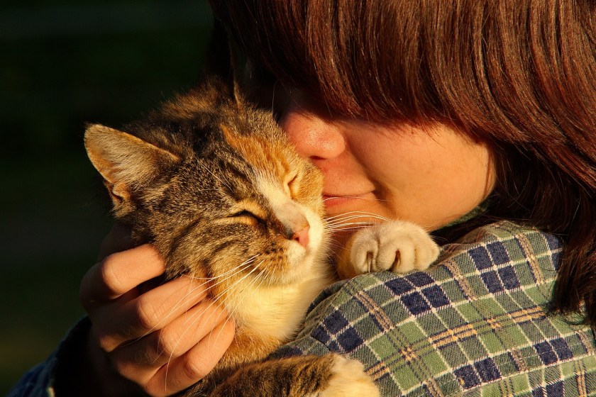 girl snuggling with cat