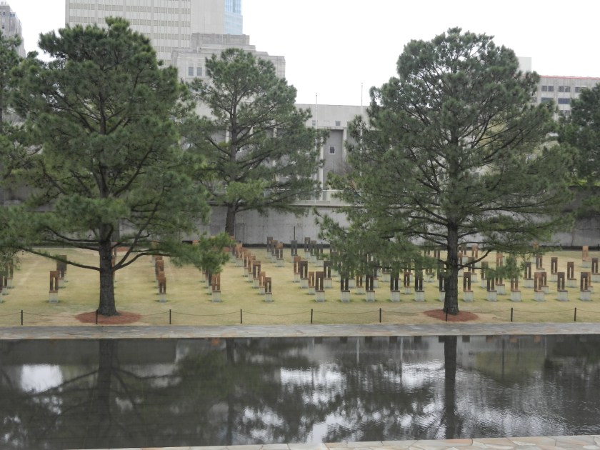 gold memorial chairs surrounded by trees at the Oklahoma National Memorial
