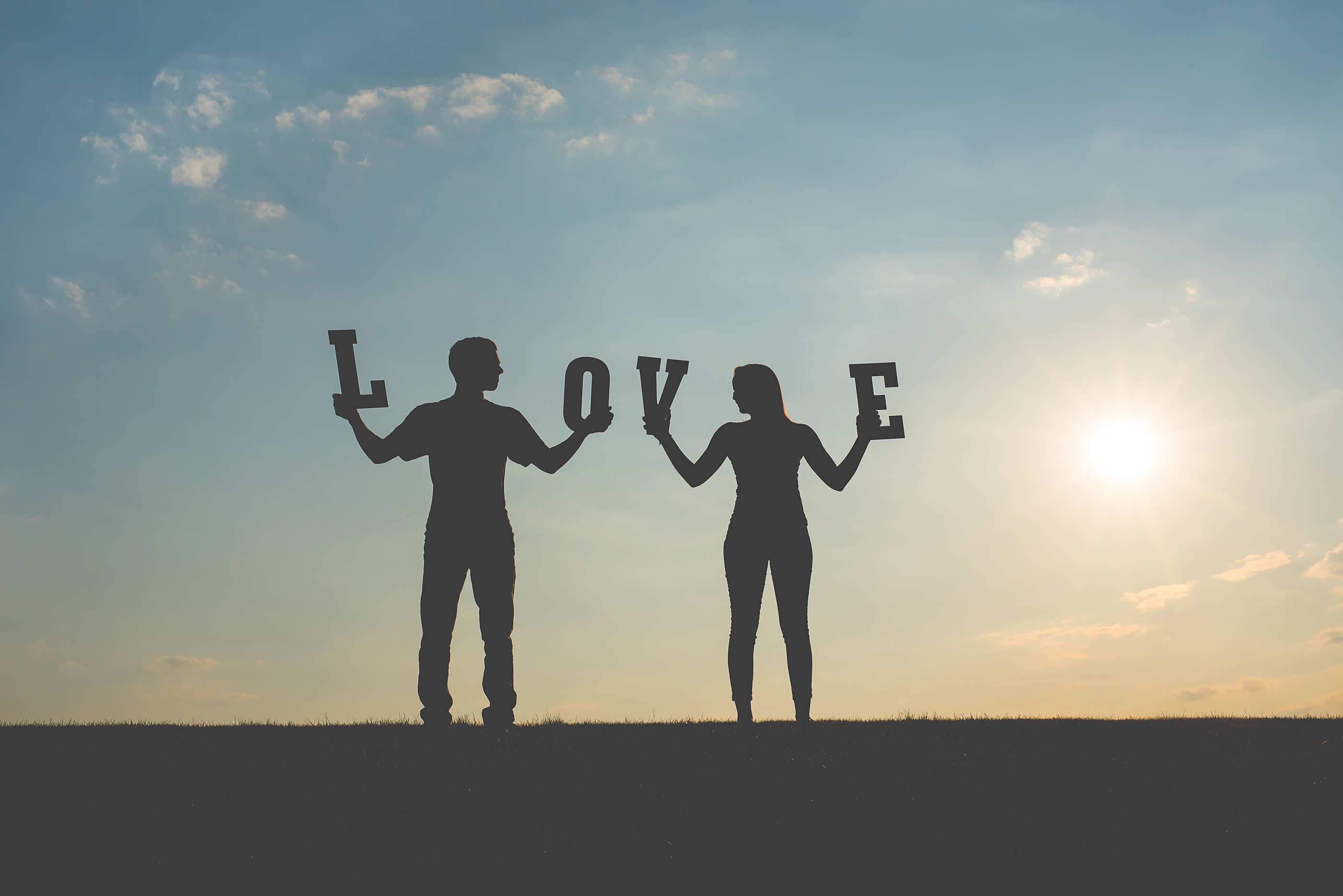 man and woman holding the letters L O V E