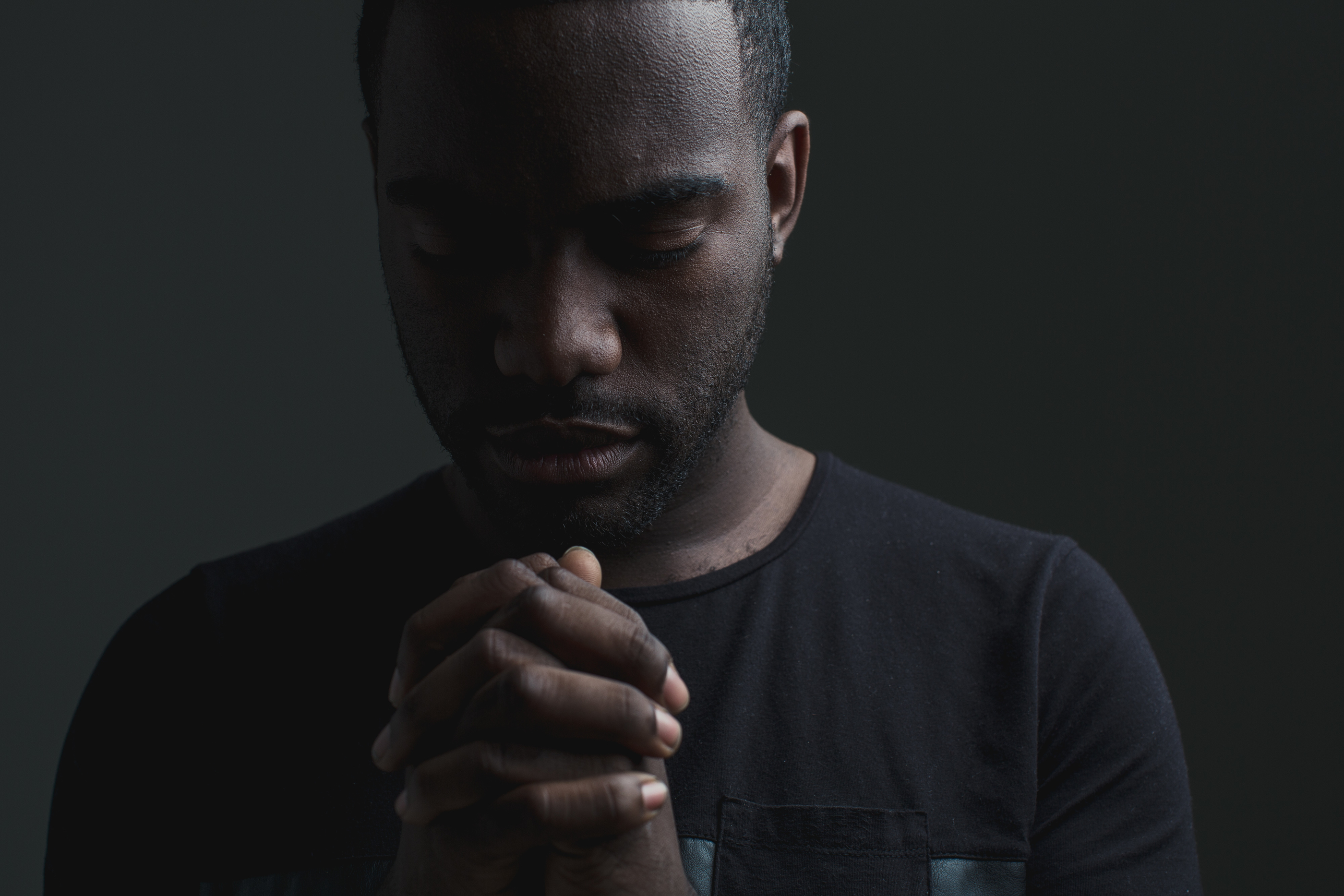 man with hands folded in prayer