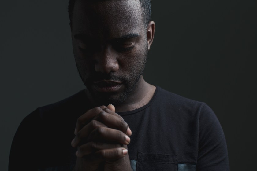 man with hands folded in prayer