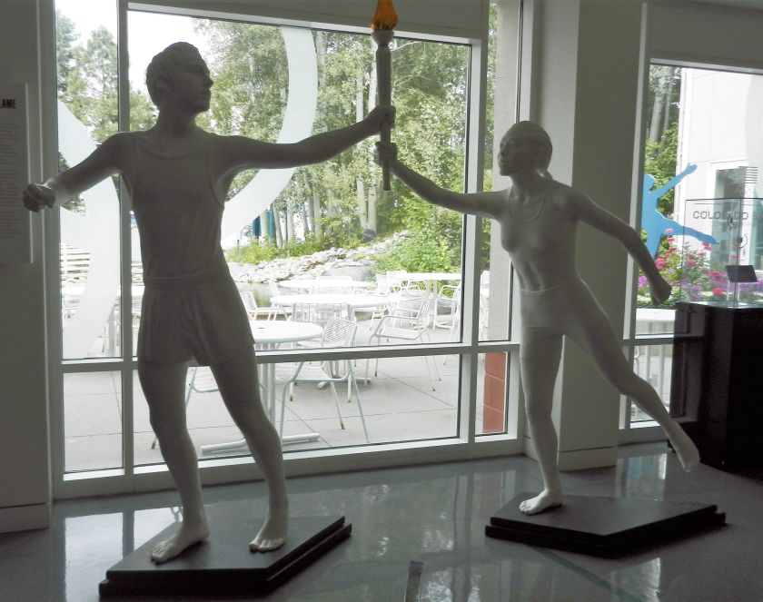 statues of runners passing a torch