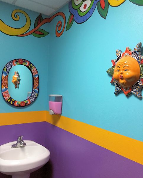 a sink with colorful wall decorations