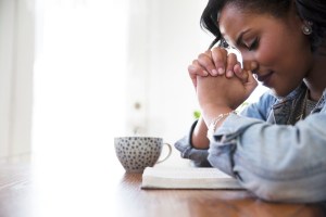 woman with hands bowed in prayer