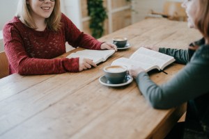 2 women talking over coffee with open bibles