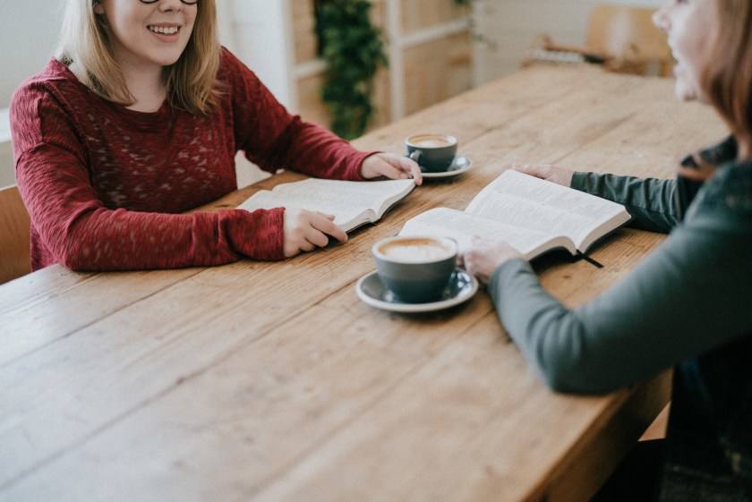 2 women talking over coffee with open bibles