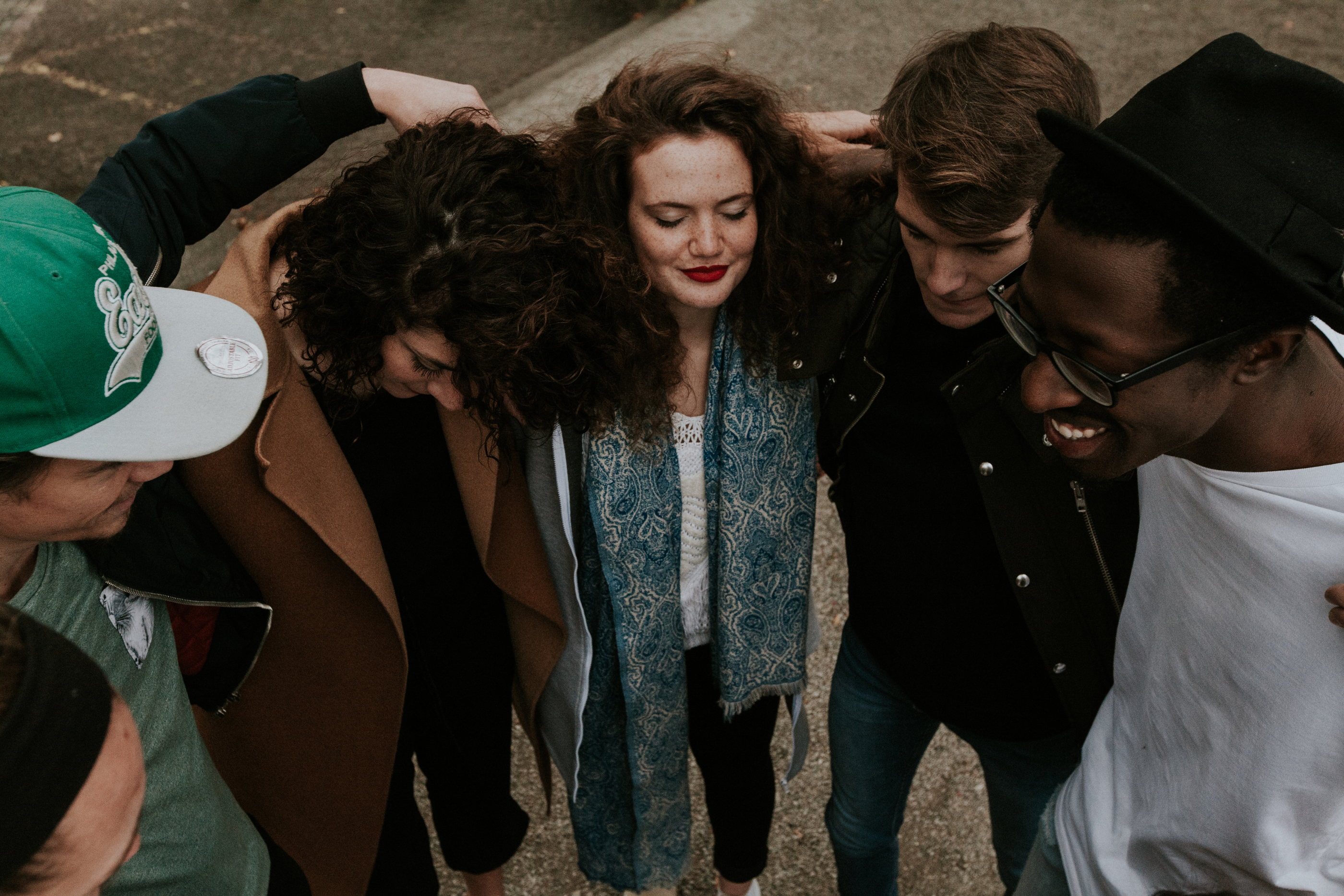 5 people young men and women with arms overlapping their shoulders