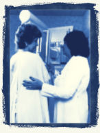 a woman having a mammogram done by a technician