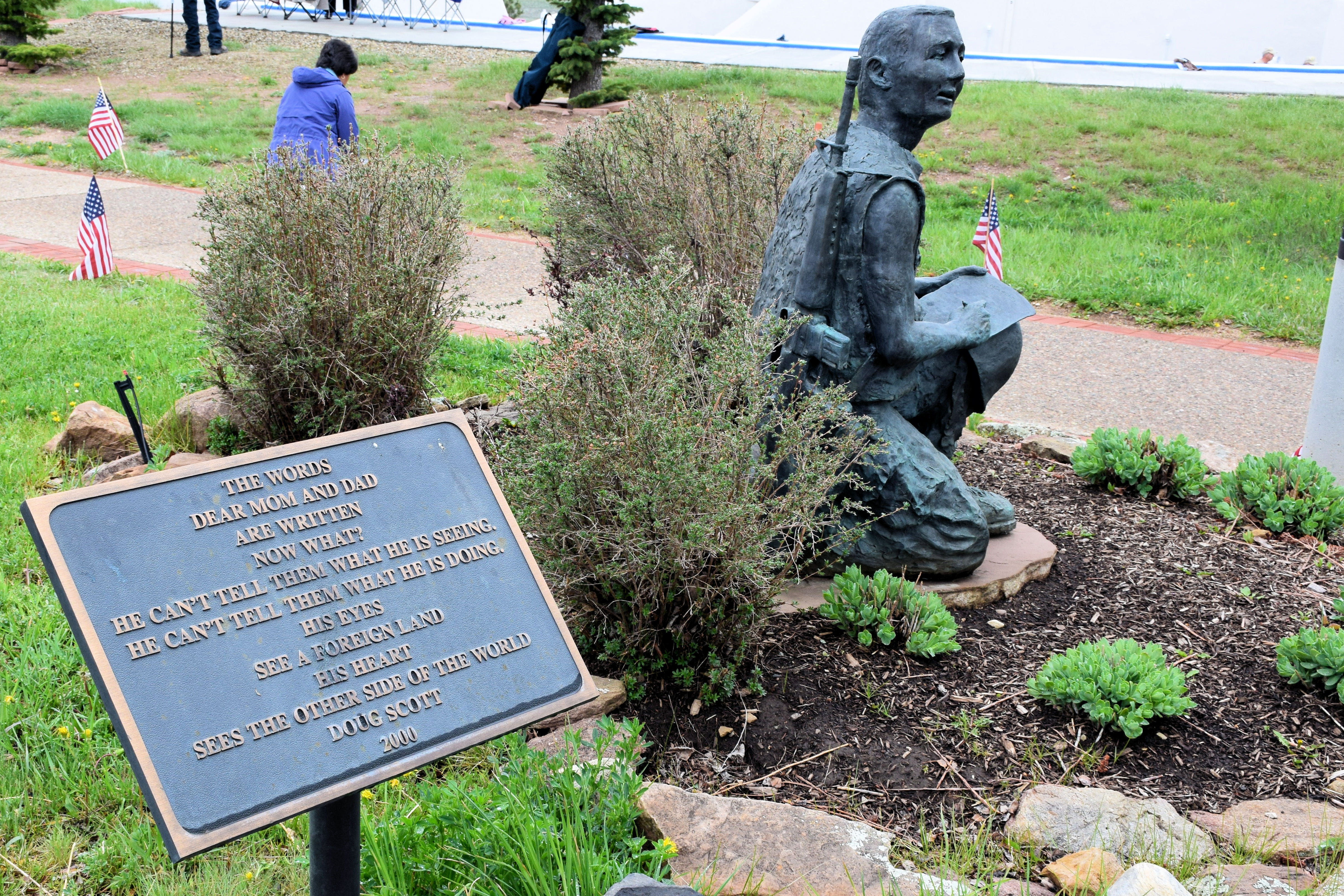 statue of a soldier in a small flower bed