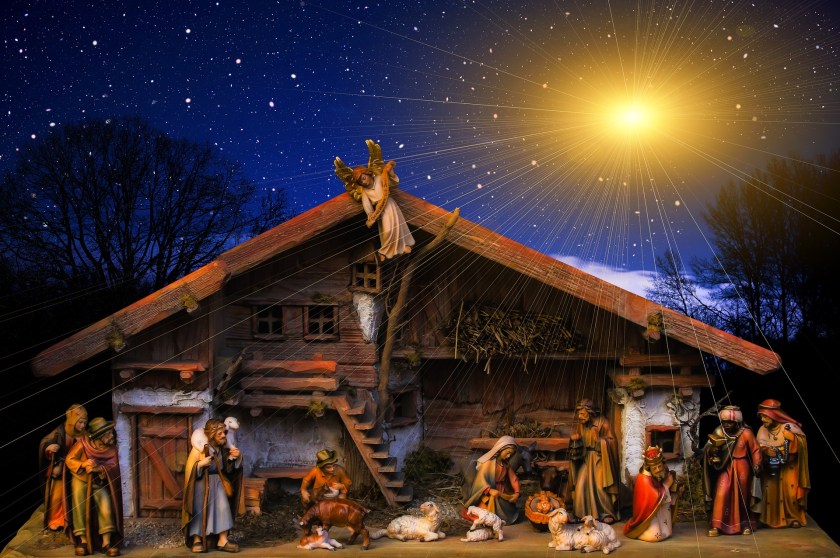 figures in a nativity scene with a bright start in the sky