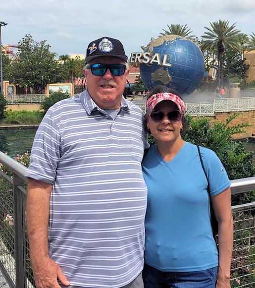 a man and woman standing in front of world globe at Universal Studios