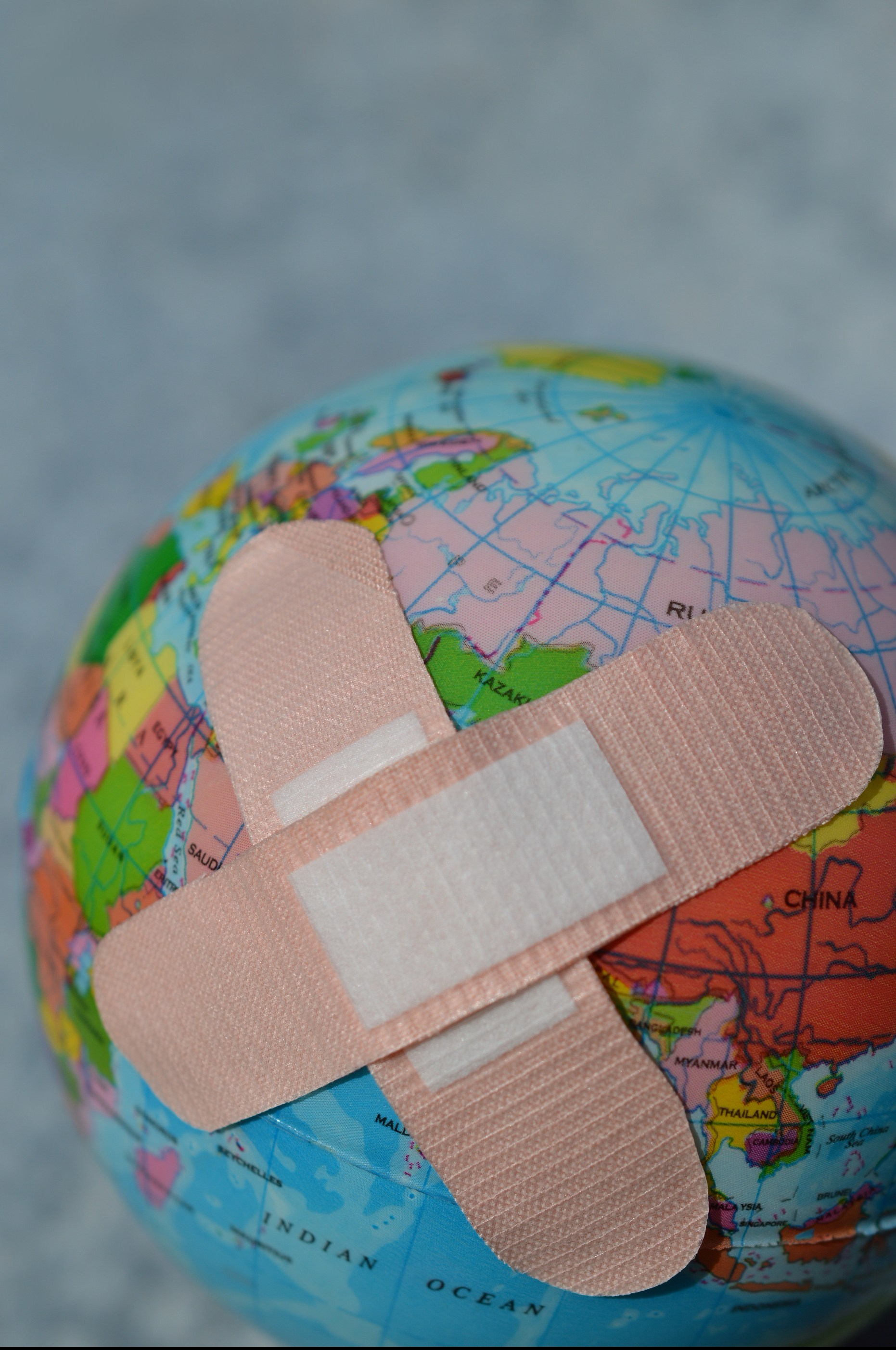 a world globe with two crossed bandaids
