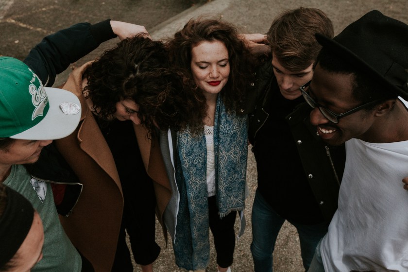 diverse people standing arm in arm