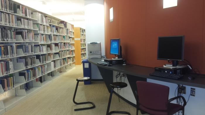 shelves in a library with adjacent computers