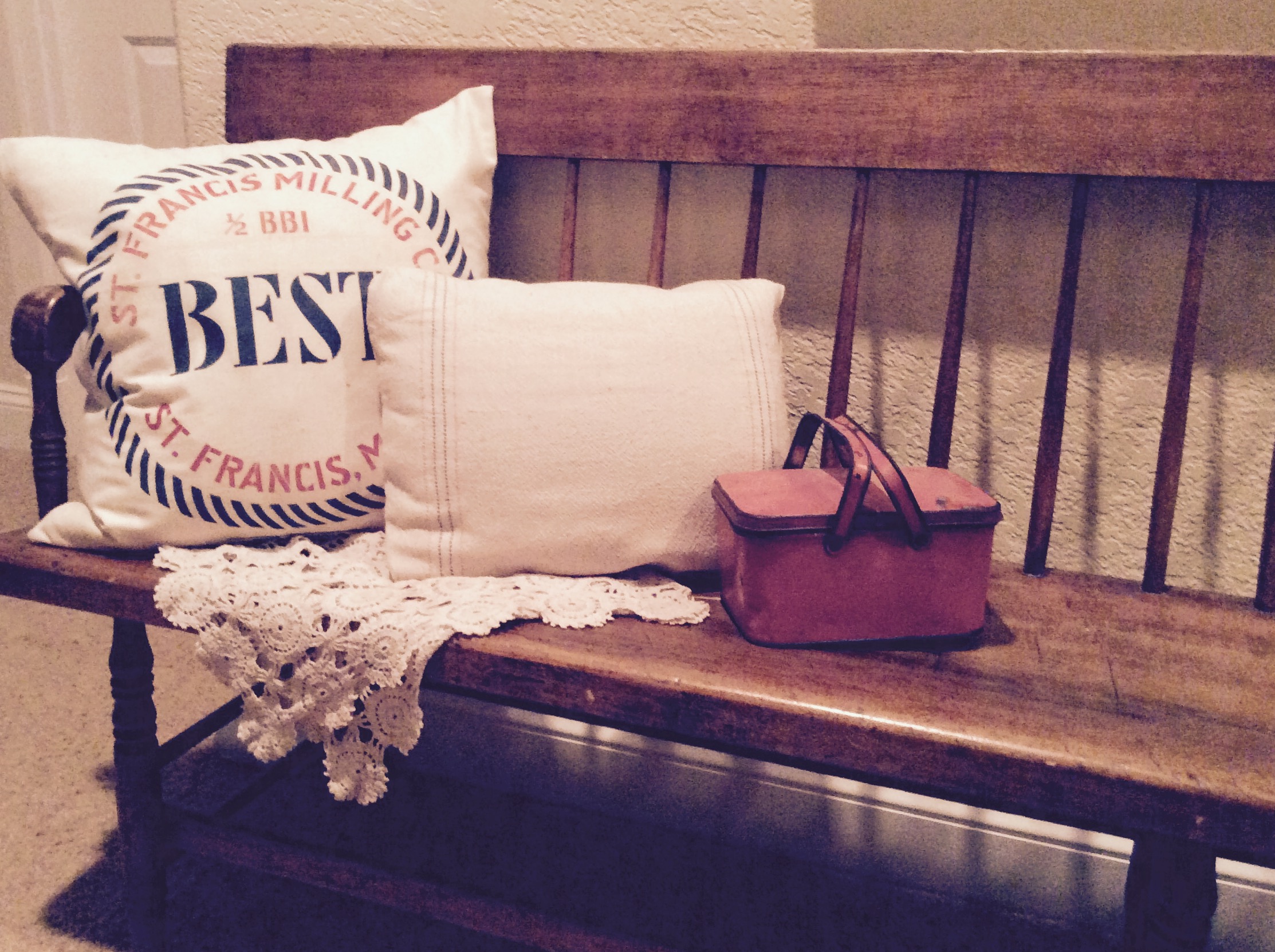 a bench with pillows and a basket