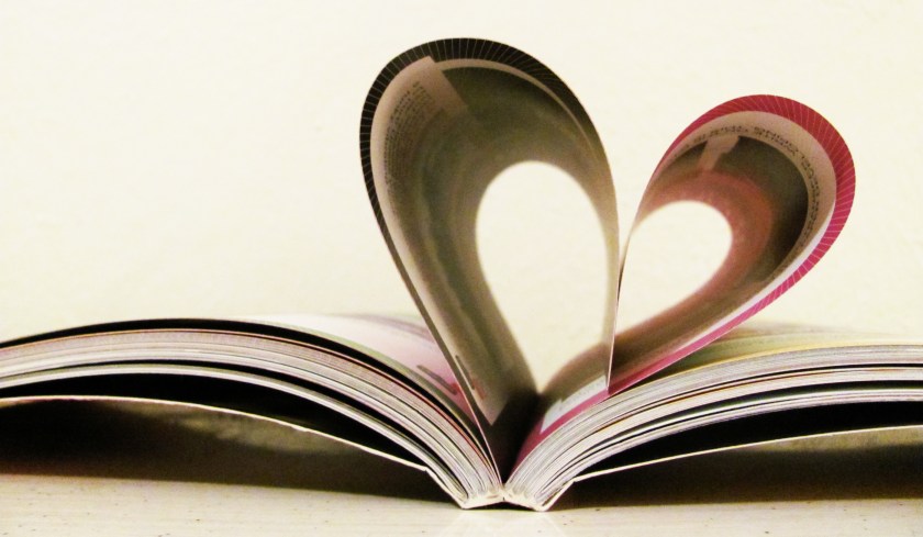 an open book with pages folded to make a heart