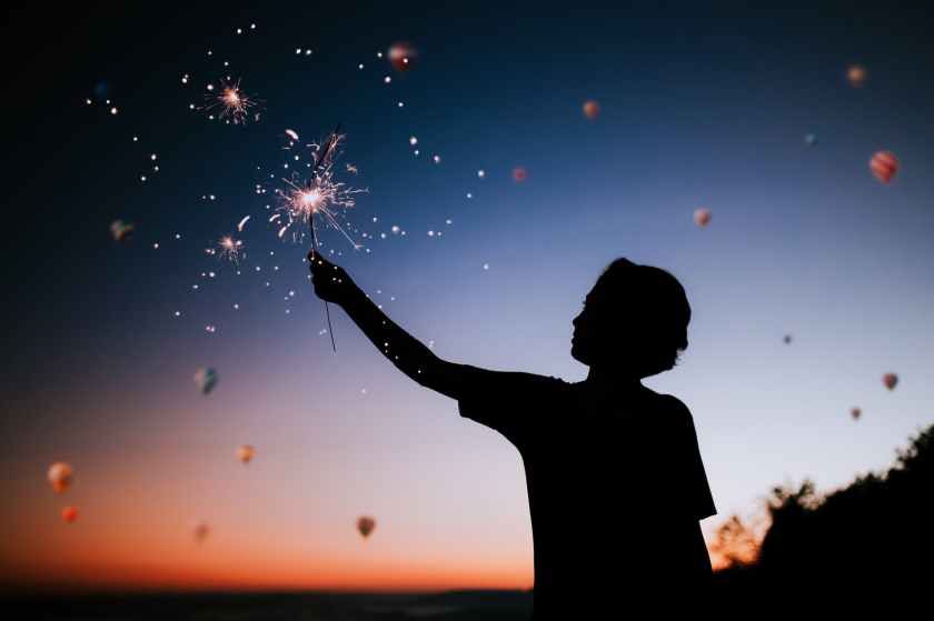 boy holding a sparkler at dawn