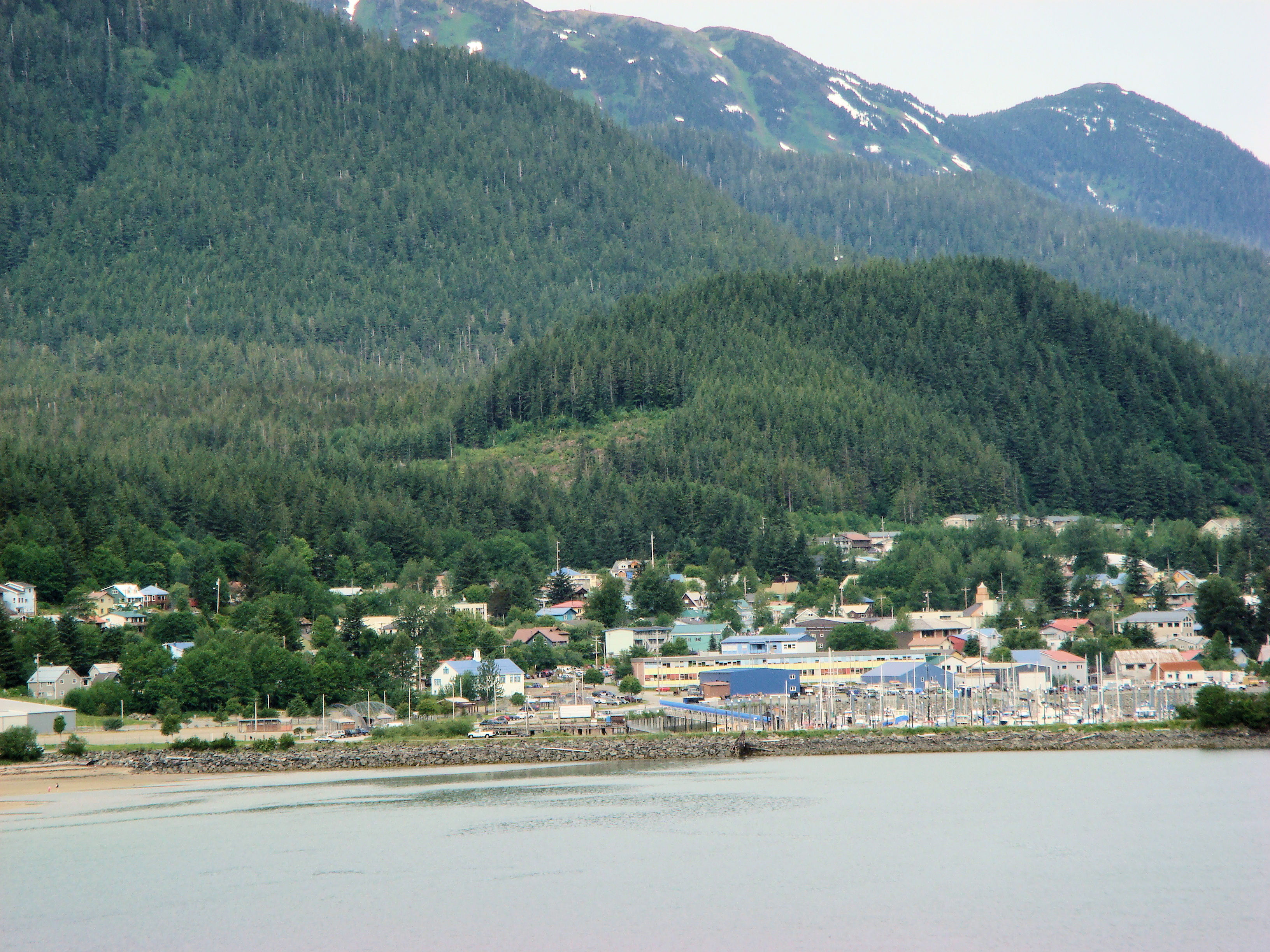 a village by the shore flanked by mountains, Alaska
