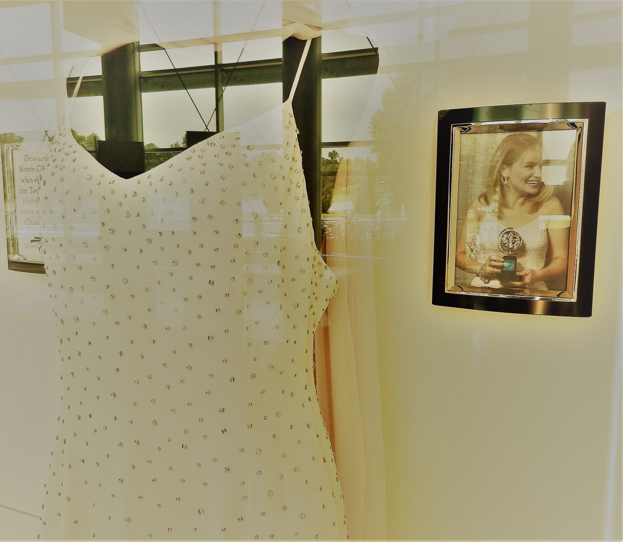 an evening gown on display next to a photo of Kristen Chenoweth
