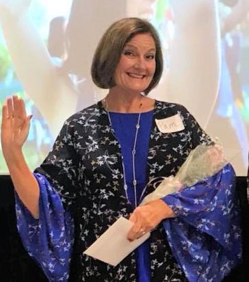 a smiling woman holding flowers