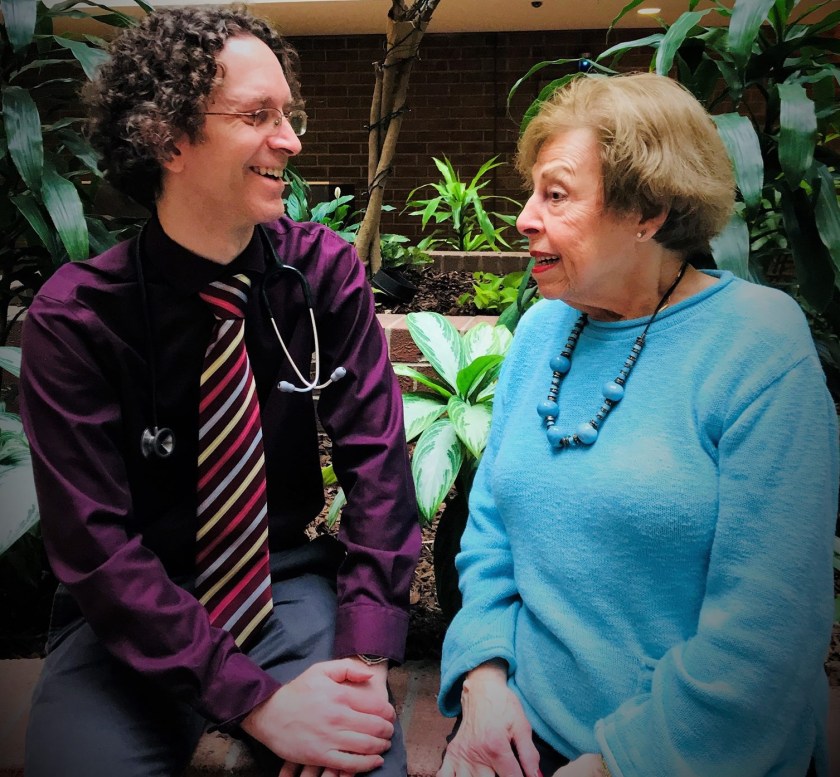 a male doctor talking to a middle aged woman