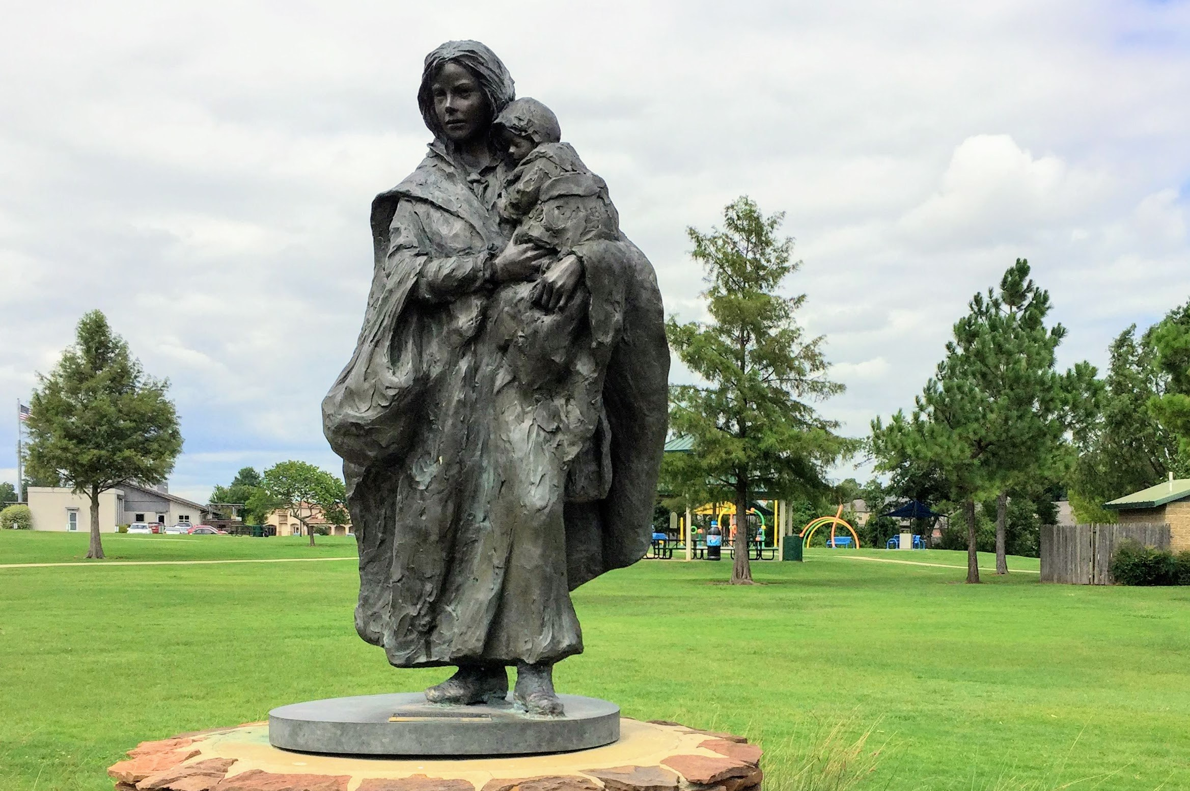 a statue of a woman holding a child, "CROSSING THE PRAIRIE"