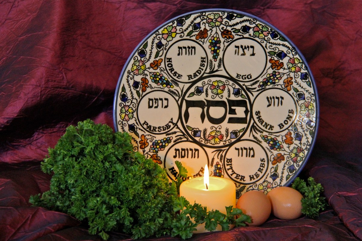 a Jewish passover seder plate with a lit cancle