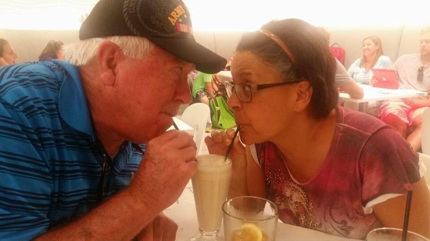 a couple sipping from a shake with two straws