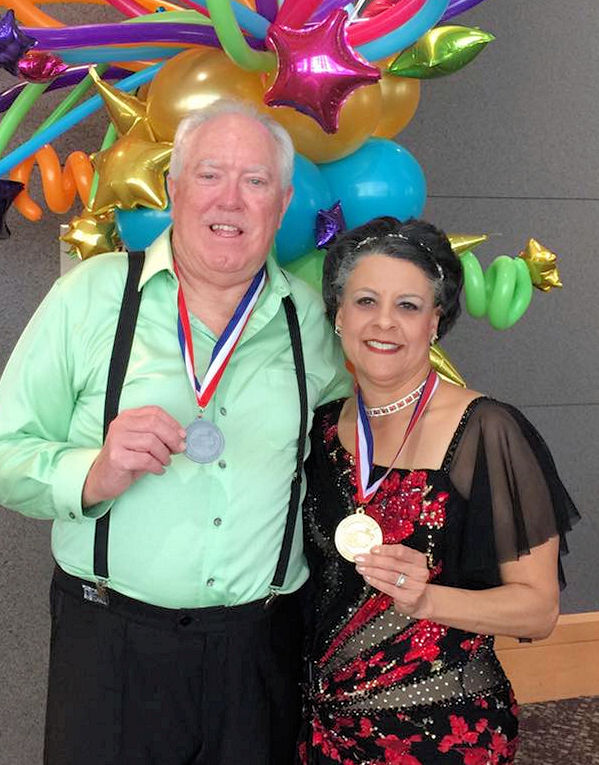 a couple in fancy clothes with medals around their necks