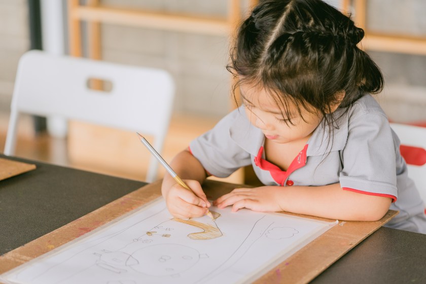 a little girl drawing a picture