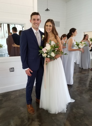 a bride and groom posing with flowers
