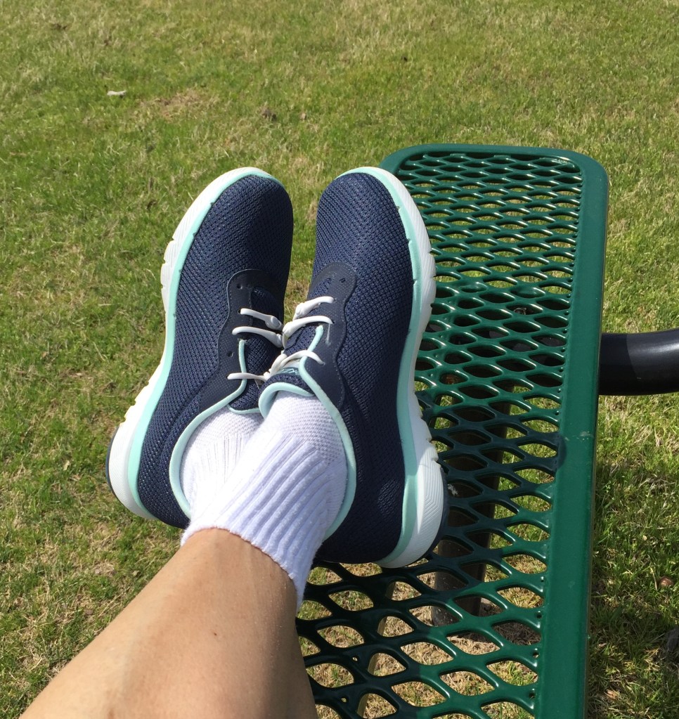 feet in walking shoes, crossed on a bench