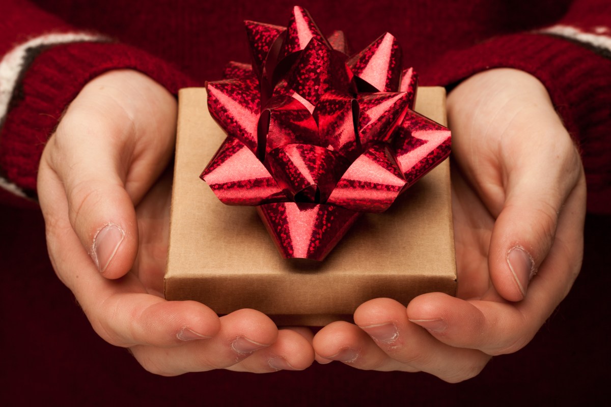 hands holding a small box with a red bow