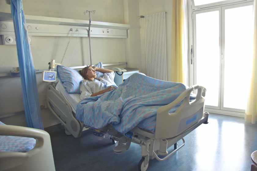 a woman lying in a  bed in a hospital room