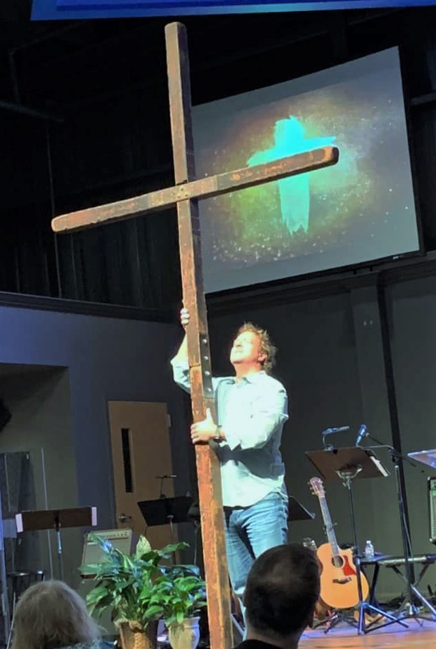 a man holding a large cross