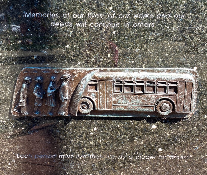 Each person must live their life as a model for others. a sculpture relief of a bus, with people standing to board.