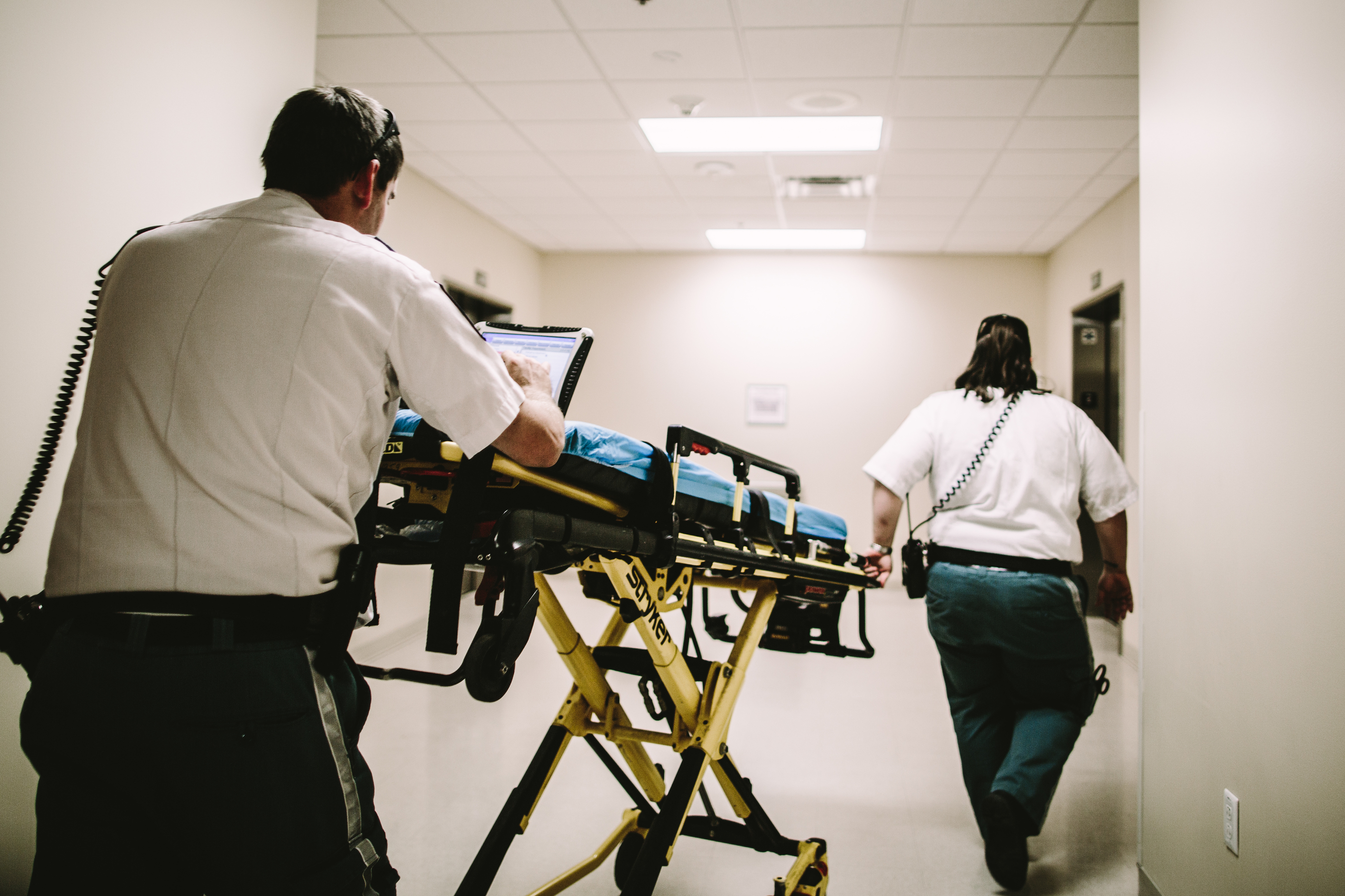 a stretcher pushed by two EMS personnel