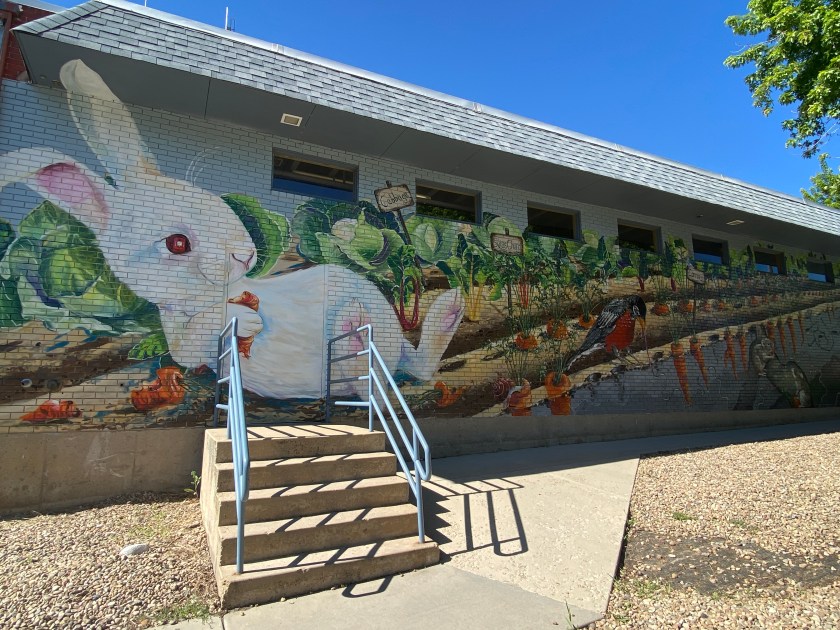 a white rabbit painted on a brick wall
