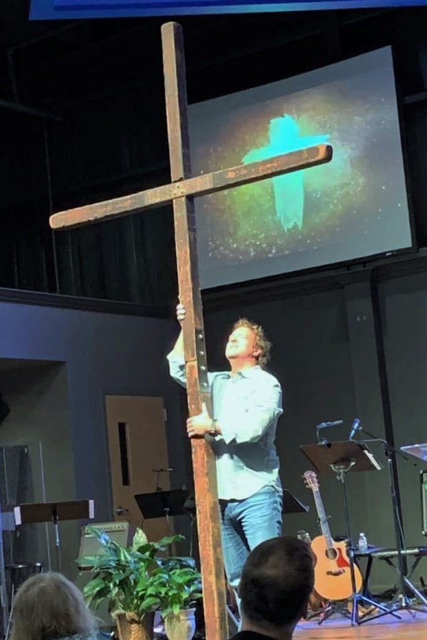 a man holding a large cross